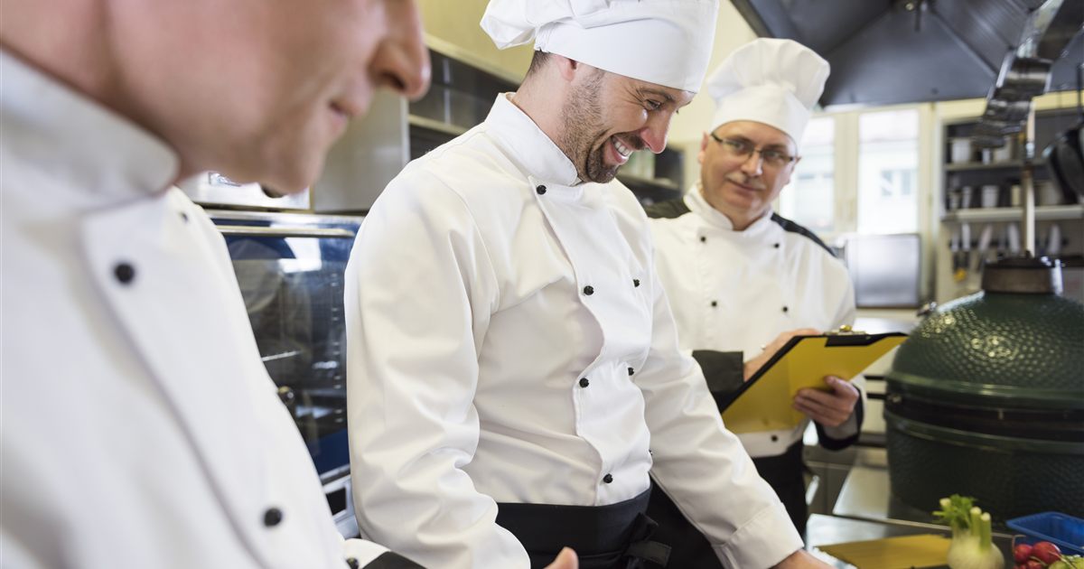 Inspecteur passant en revue les points de contrôle avec l'équipe de cuisine
