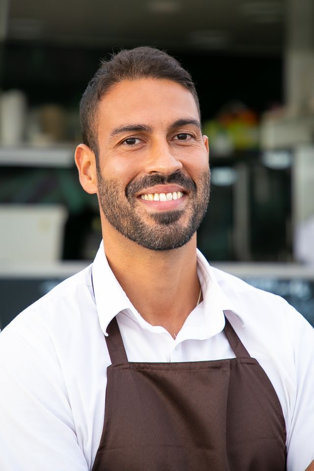 Chef souriant devant sa cuisine